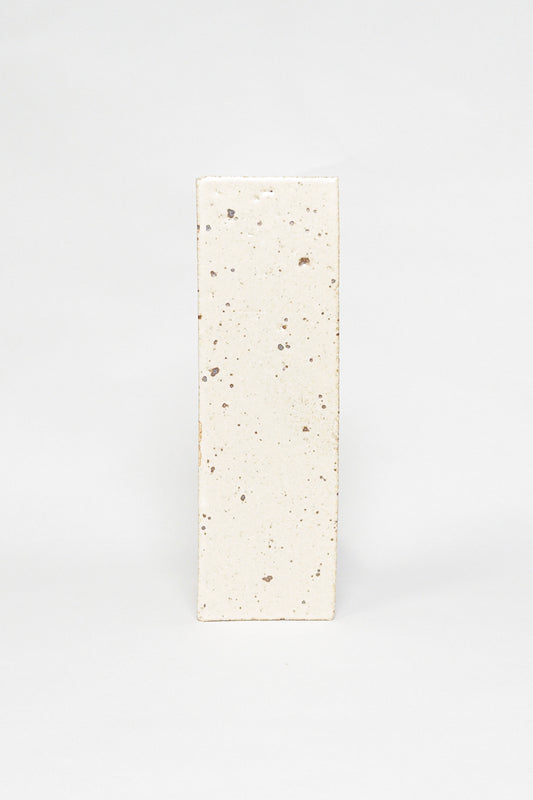 Artisan Antiquity cream thin brick tile with a matte glaze and scattered dark speckles