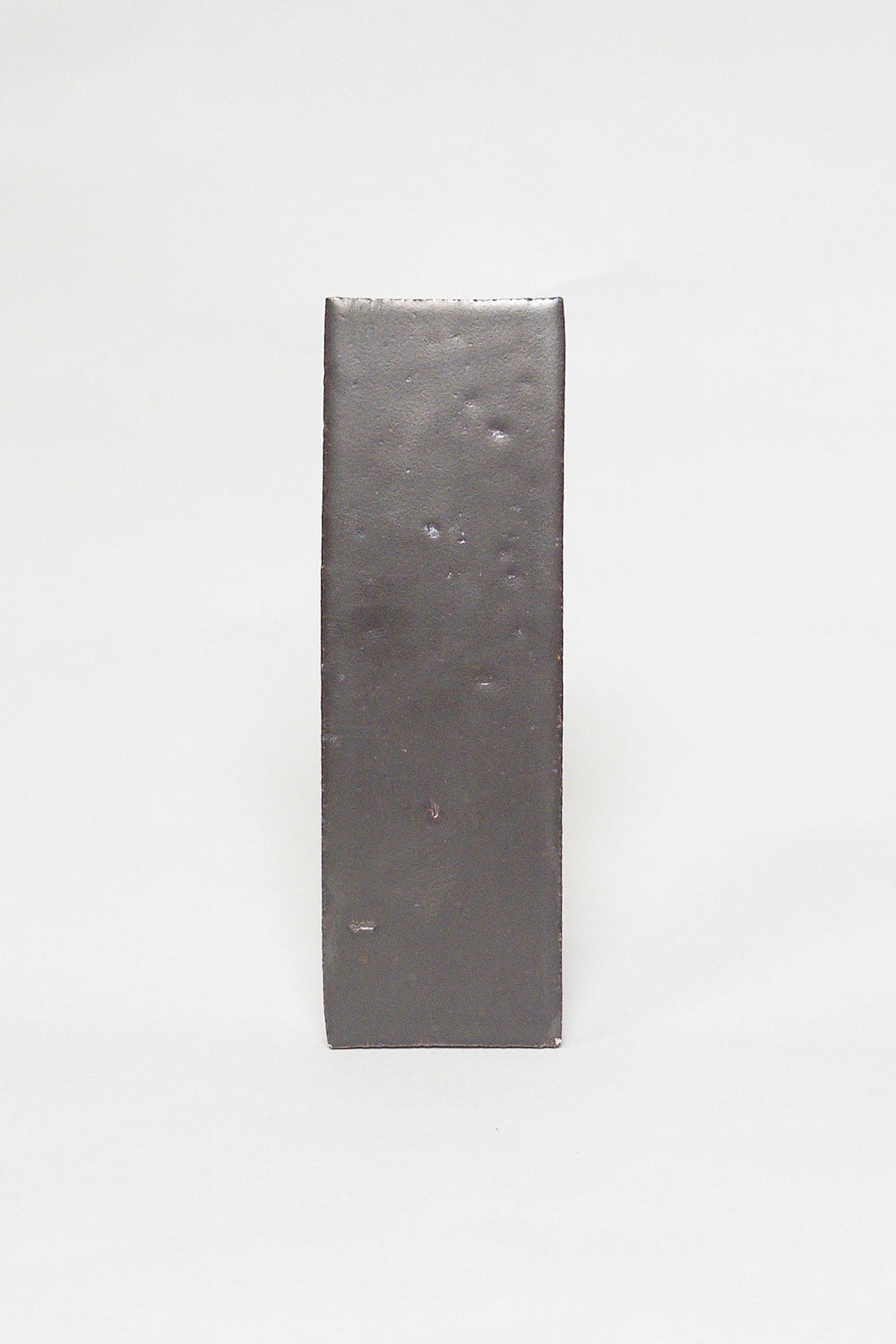 Artisan Baked smoky dark brown thin brick tile with a matte glaze and textured surface