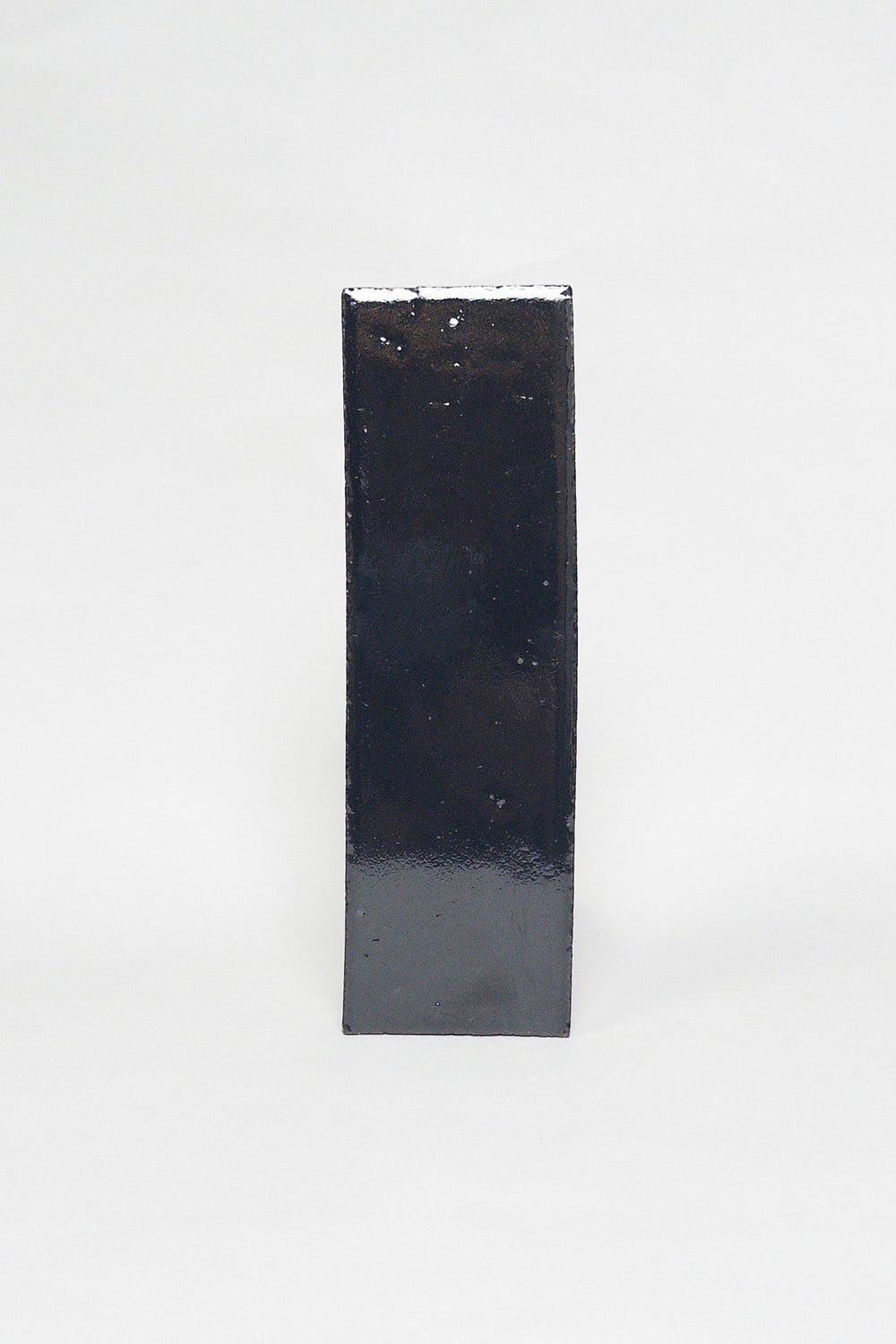 Artisan Caviar black thin brick tile with a glossy glaze and subtly uneven surface