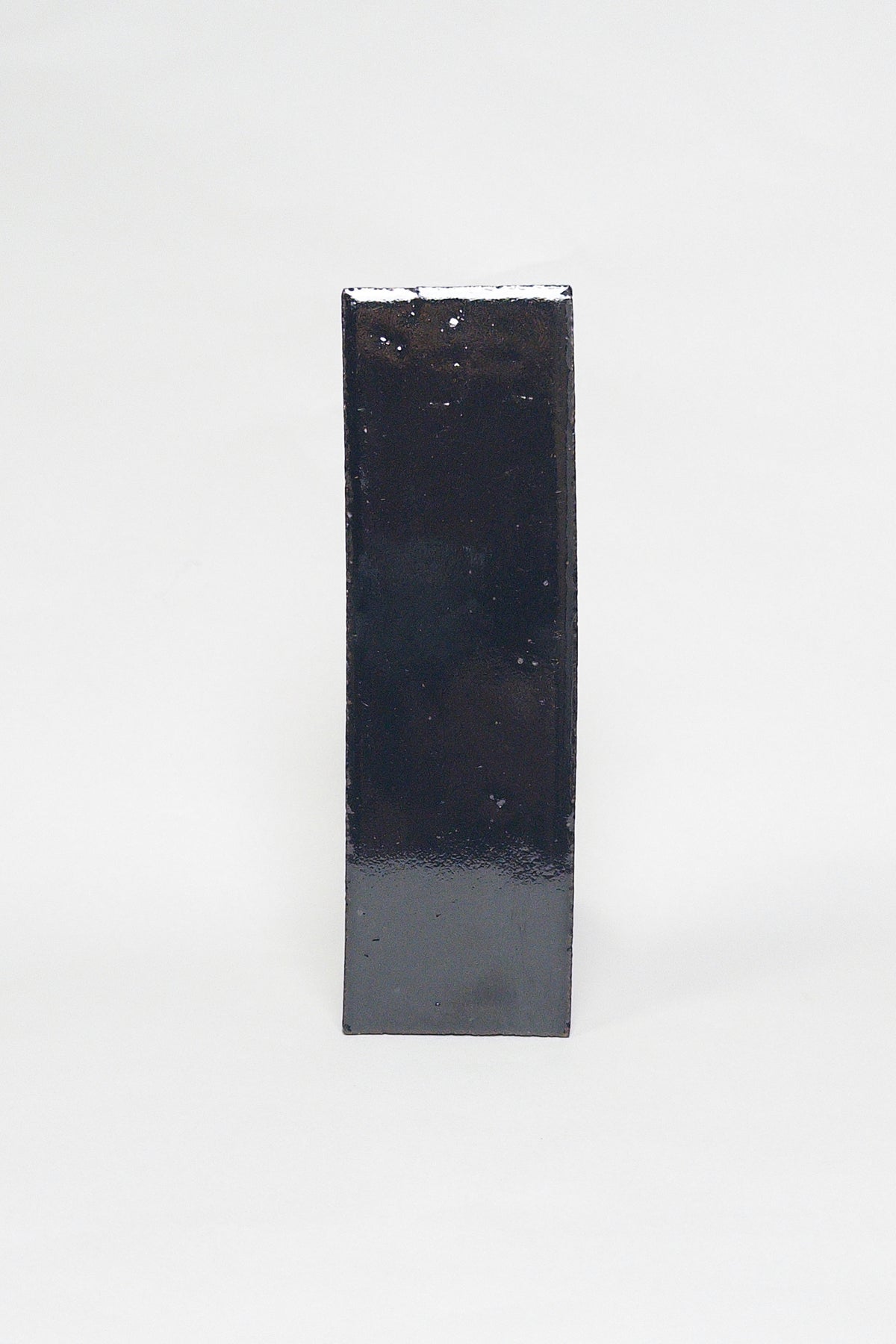Artisan Caviar black thin brick tile with a glossy glaze and subtly uneven surface