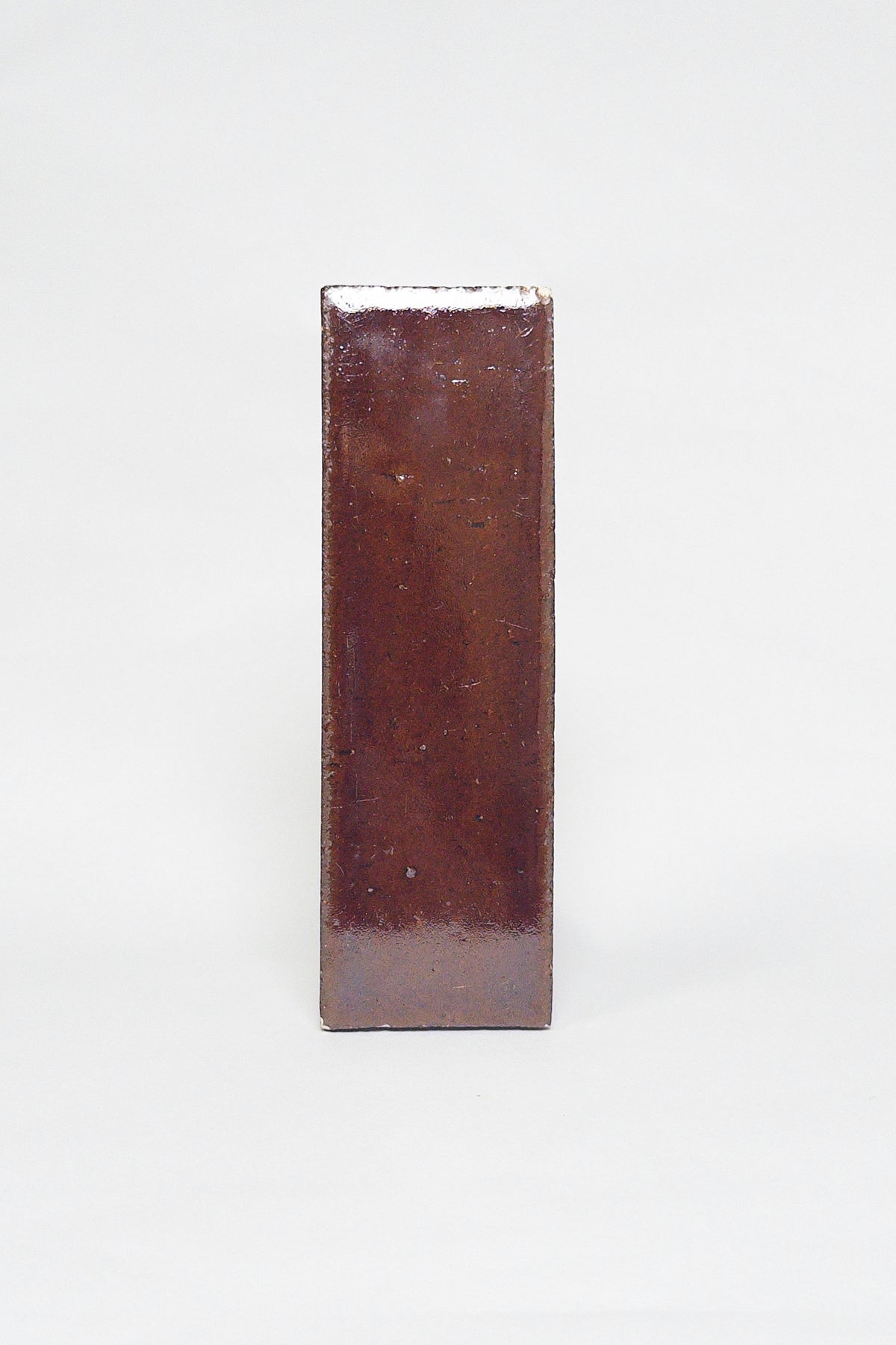 Artisan Java reddish brown thin brick tile with a glossy glaze and rich tonal variation