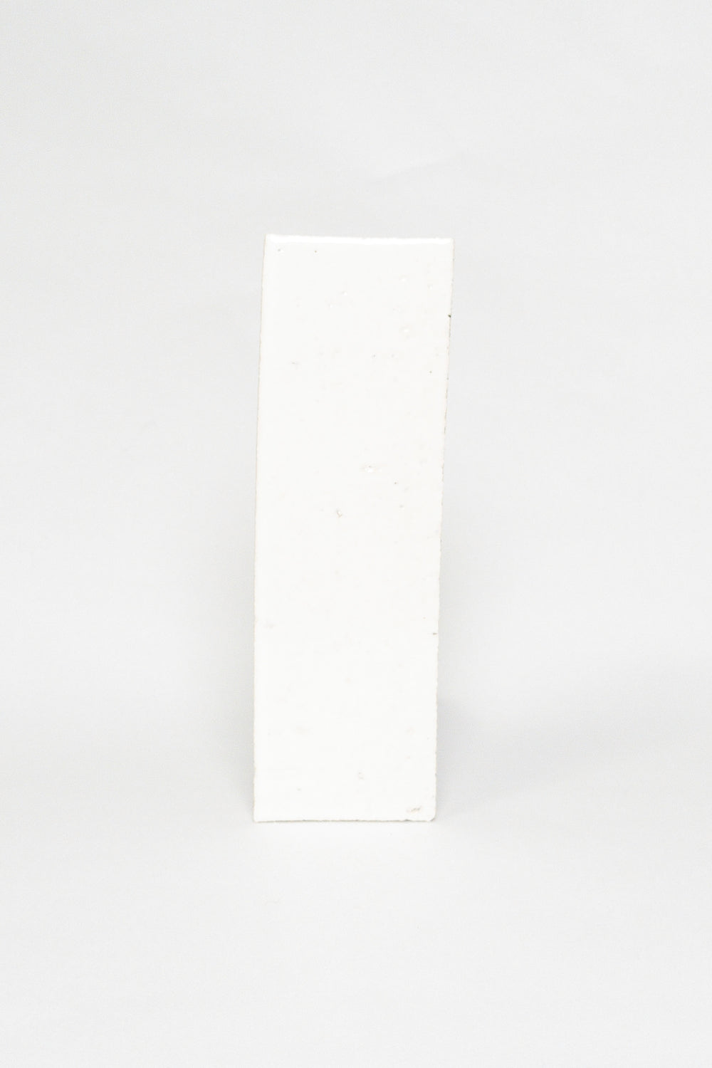 Artisan Oat Milk white thin brick tile with a glossy glaze and textured edges