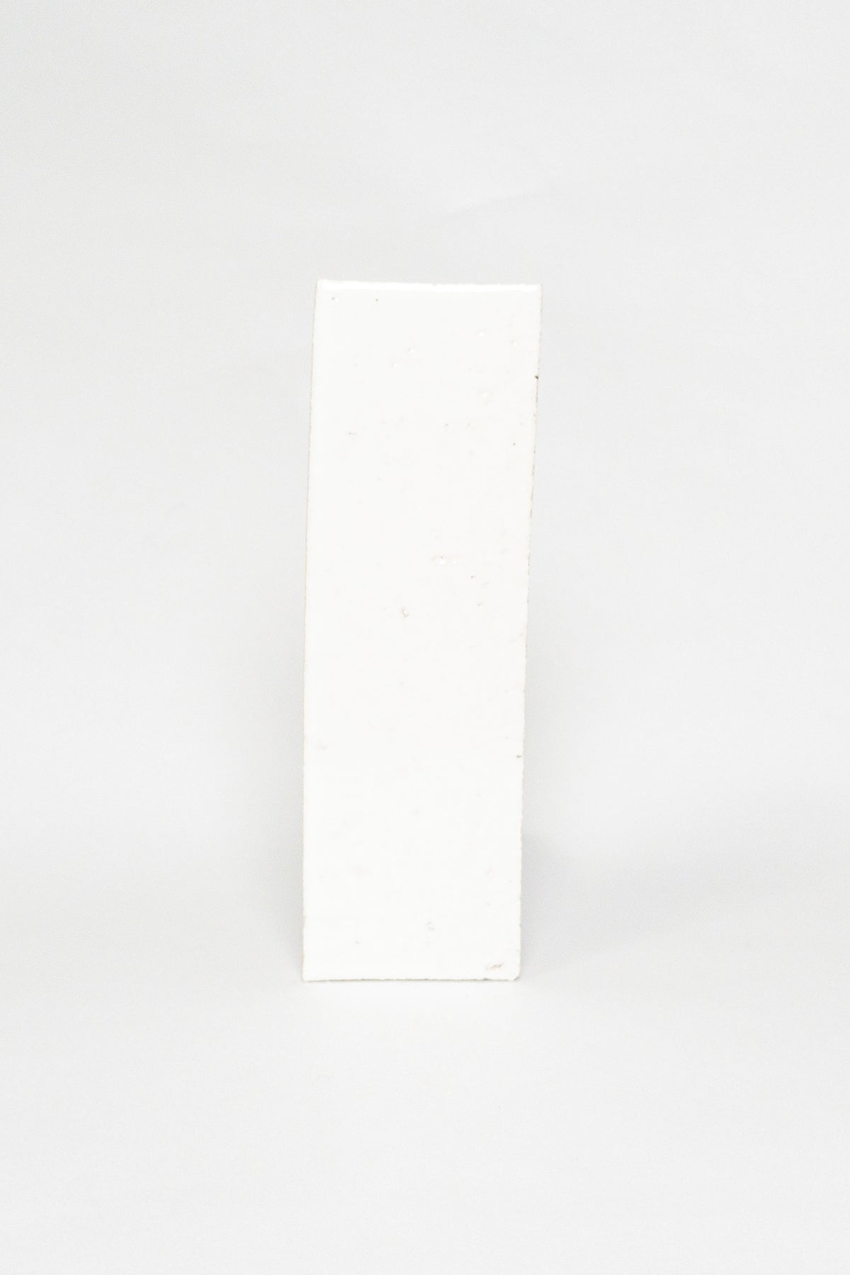Artisan Oat Milk white thin brick tile with a glossy glaze and textured edges